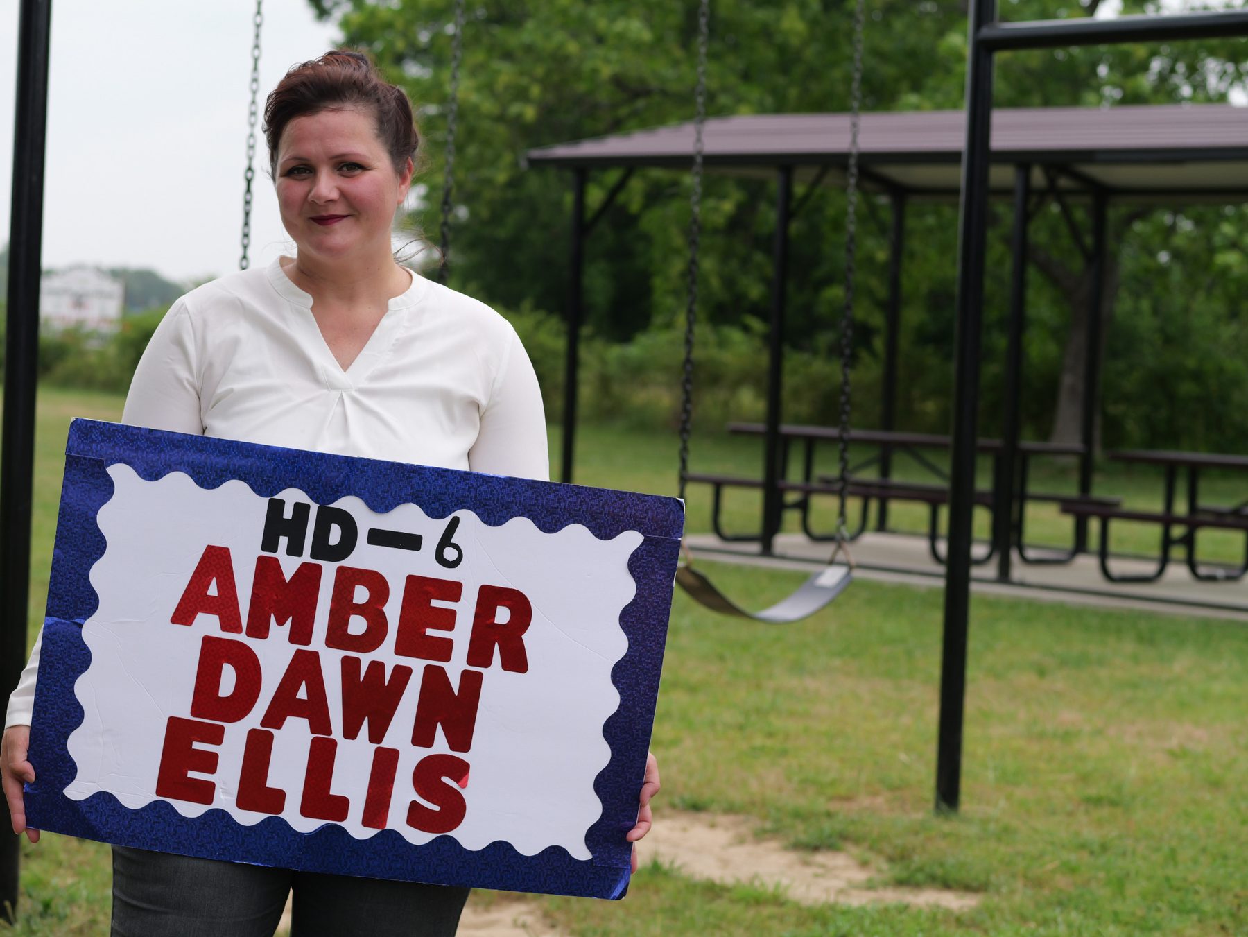 Amber Dawn Ellis holding a Protect Our Land sign